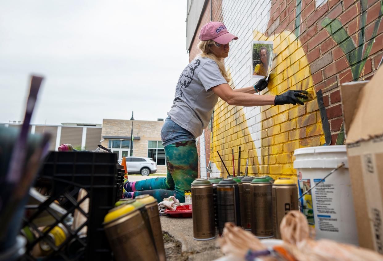 Artist Brittany Johnson paints a mural at Hammer & Quill on Thursday, July 7, 2022.