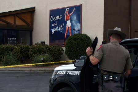 A Texas state trooper monitors the scene at a Twin Peaks restaurant following a shooting in Odessa