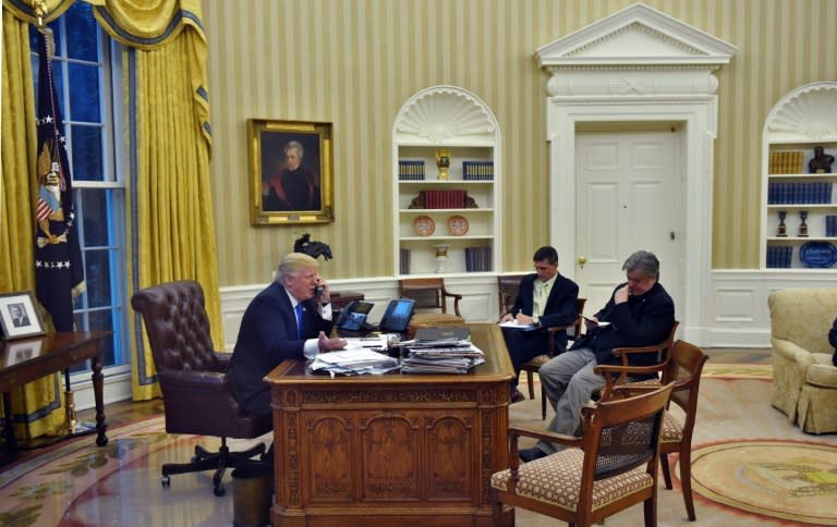 US President Donald Trump speaks on the phone with Australians Prime Minister Malcolm Turnbull, alongside Chief Strategist Steve Bannon (R) and National Security Advisor Michael Flynn, in the Oval Office on January 28, 2017