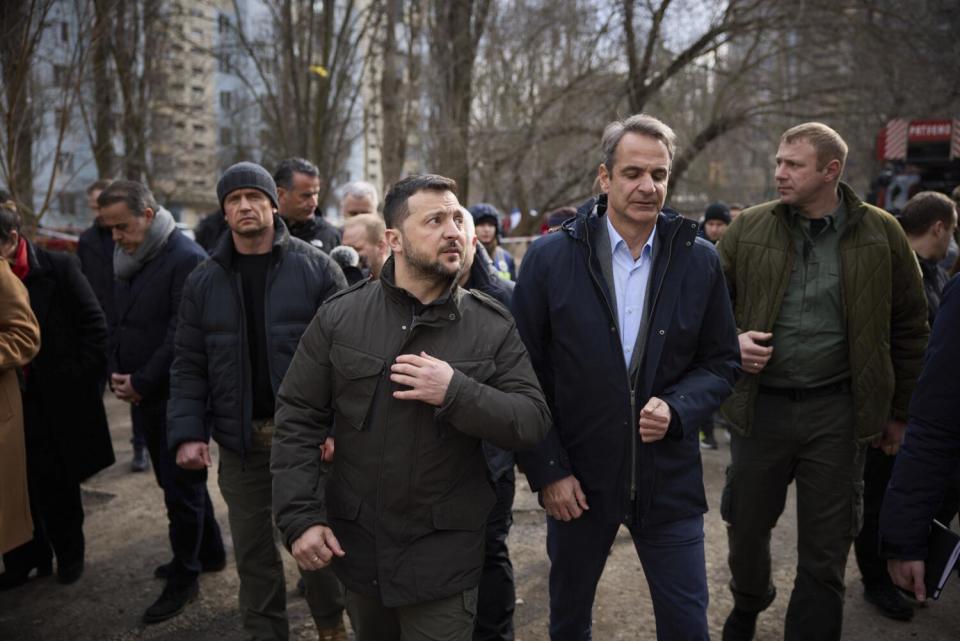 Ukrainian President Volodymyr Zelensky and Greek Prime Minister Kyriakos Mitsotakis walk near trees in Odesa, Ukraine.