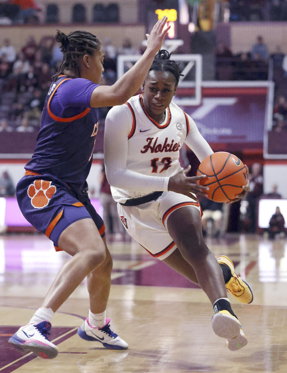 Virginia Tech's Samyha Suffren (12) drives on Clemson's Dayshanette Harris (1) in the first half of an NCAA college basketball game in Blacksburg, Va, Sunday, Jan. 21, 2024. (Matt Gentry/The Roanoke Times via AP)