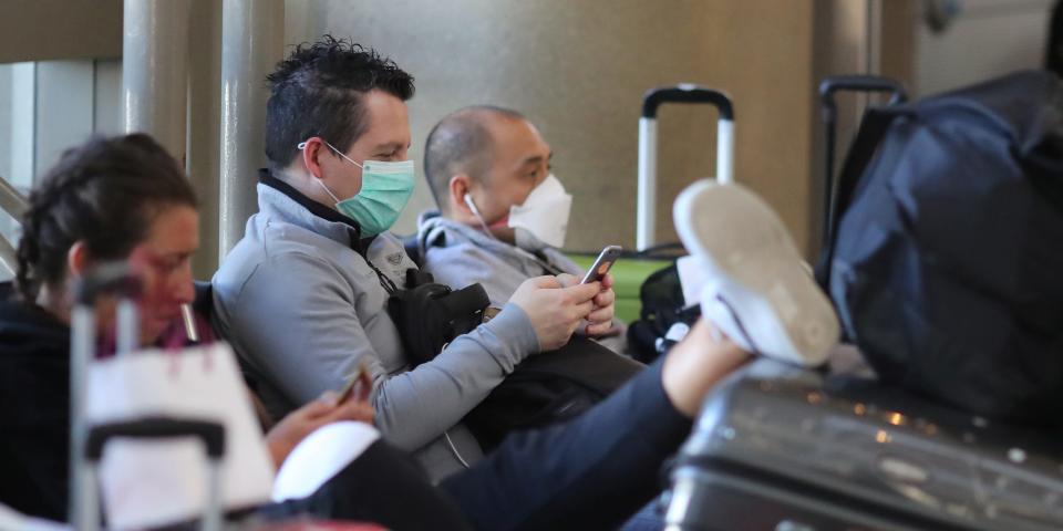 People wear masks at the international terminal at LAX airport in Los Angeles, California, U.S., amid reports of the coronavirus, March 11, 2020. REUTERS/Lucy Nicholson