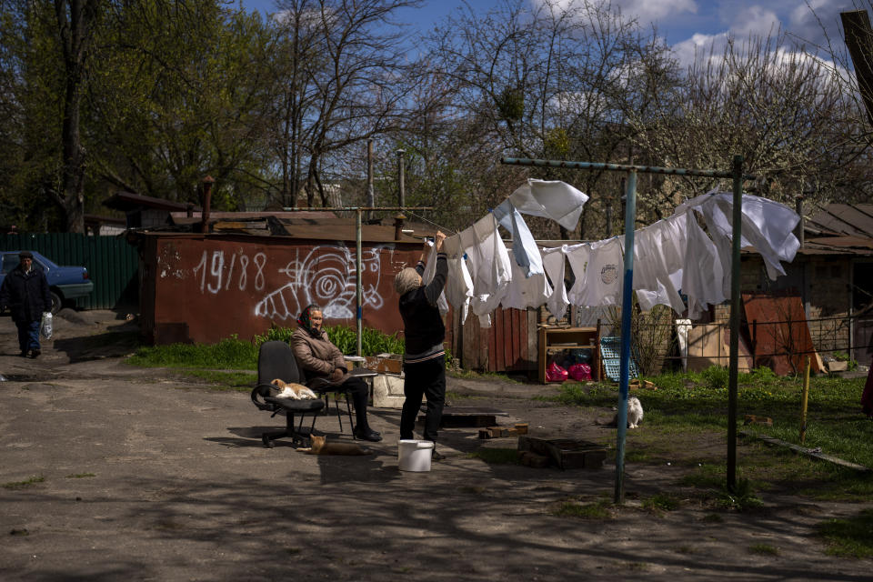 A woman hangs out the washing next to her house in Bucha, on the outskirts of Kyiv, on Wednesday, April 27, 2022. (AP Photo/Emilio Morenatti)
