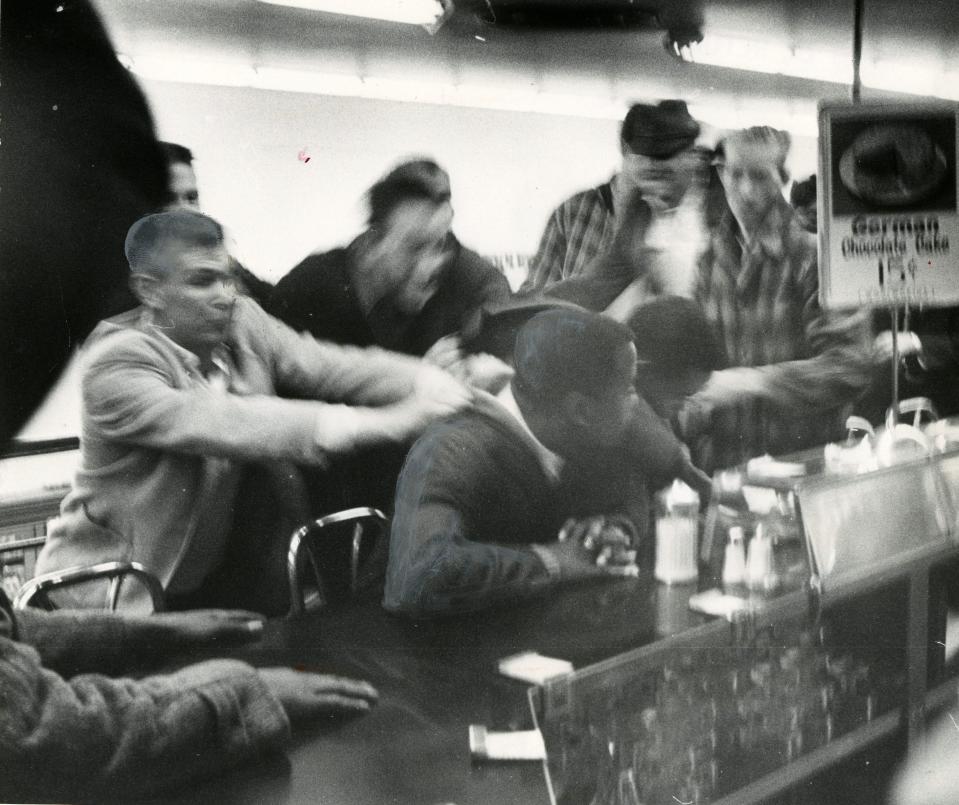 John Lewis is pulled off a stool during a sit-in at a segregated lunch counter in Nashvillle in the 1960s.