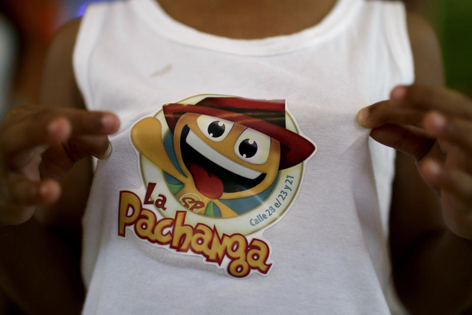 In this June 9, 2012 photo, Alessandro Martinez shows a sticker on his shirt advertising the private cafeteria "La Pachanga" where his father works as a security guard in Havana. For decades, Communist-run Cuba has essentially been free of commercial advertising. But it's a knotty problem for thousands of budding entrepreneurs who have embraced President Raul Castro's push for limited free-market reform. So they're turning to guerrilla marketing. (AP Photo/Franklin Reyes)