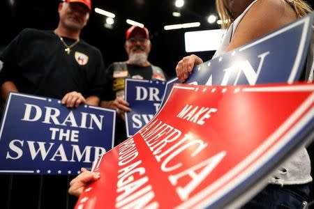 Volunteer Danielle Miller hands out signs during a rally with U.S. President Donald Trump at the U.S. Cellular Center in Cedar Rapids, Iowa, U.S. June 21, 2017. REUTERS/Scott Morgan