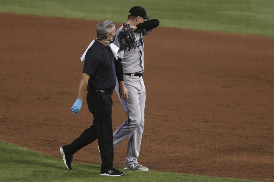 Miami Marlins pitcher Mike Morin is helped off the field during the sixth inning of a baseball game against the Toronto Blue Jays, Wednesday, Aug. 12, 2020, in Buffalo, N.Y. (AP Photo/Jeffrey T. Barnes)