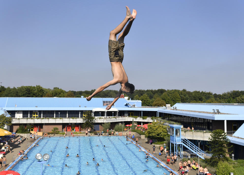 <p>Ein junger Mann hüpft in einem Schwimmbad in Gelsenkirchen von einem Sprungturm. (Bild: AP Photo/Martin Meissner) </p>