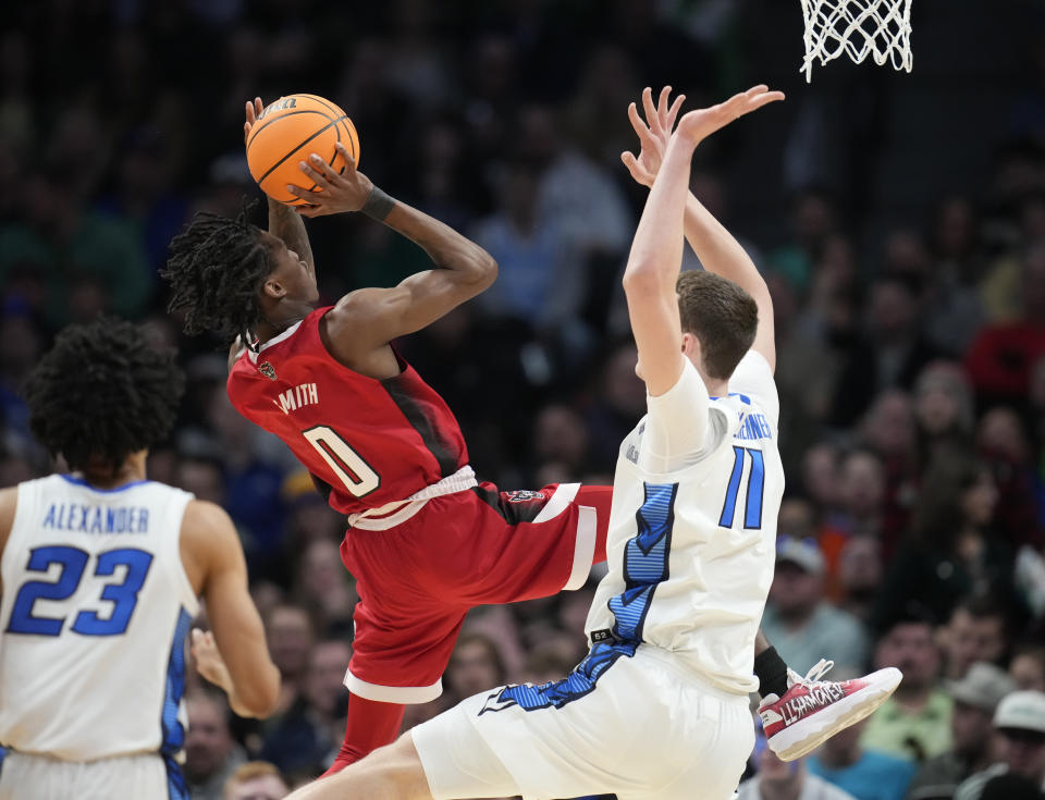 North Carolina State guard Terquavion Smith, left, shoots over Creighton center Ryan Kalkbrenner in the first half of a first-round college basketball game in the men's NCAA Tournament Friday, March 17, 2023, in Denver. (AP Photo/John Leyba)