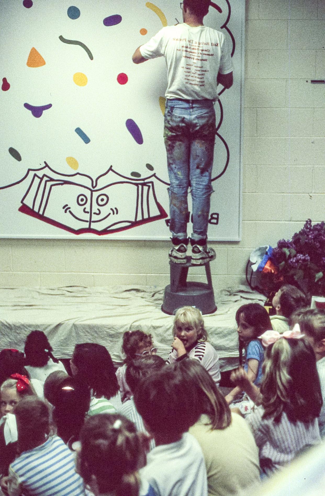 Keith Haring at work on the mural at Ernest Horn Elementary School in 1989