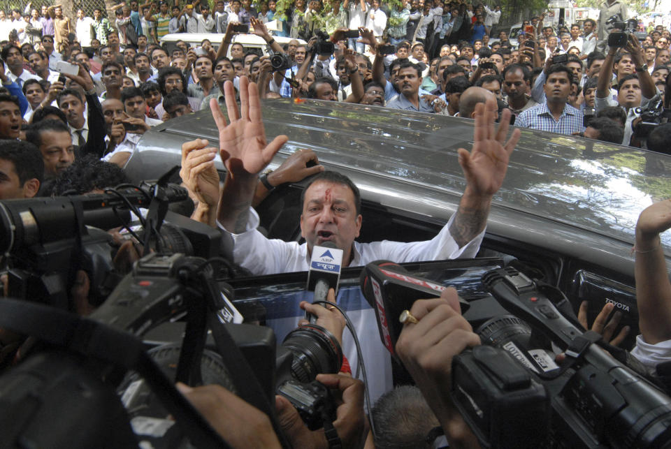 Bollywood star Sanjay Dutt, gestures to the media as he arrives at a court in Mumbai, India, Thursday, May 16, 2013. Dutt has been sentenced to five years in prison for a 1993 weapons conviction linked to a deadly terror attack in Mumbai that killed 257 people. The 53-year-old actor served 18 months in jail before being released on bail in 2007 pending an appeal. The Supreme Court reduced his prison sentence to five years from the six-year term initially handed down. (AP Photo/Rajanish Kakade)
