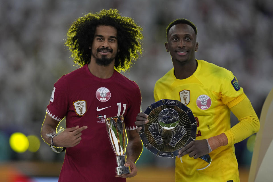 Most Valuable Player Qatar's Akram Afif, left, and Best Goalkeeper Qatar's Meshaal Barsham stand with their awards after their team won the Asian Cup final soccer match between Qatar and Jordan at the Lusail Stadium in Lusail, Qatar, Saturday, Feb. 10, 2024. (AP Photo/Thanassis Stavrakis)