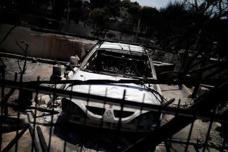 A destroyed car is seen following a wildfire in the village of Mati, near Athens, Greece, July 25, 2018. REUTERS/Alkis Konstantinidis