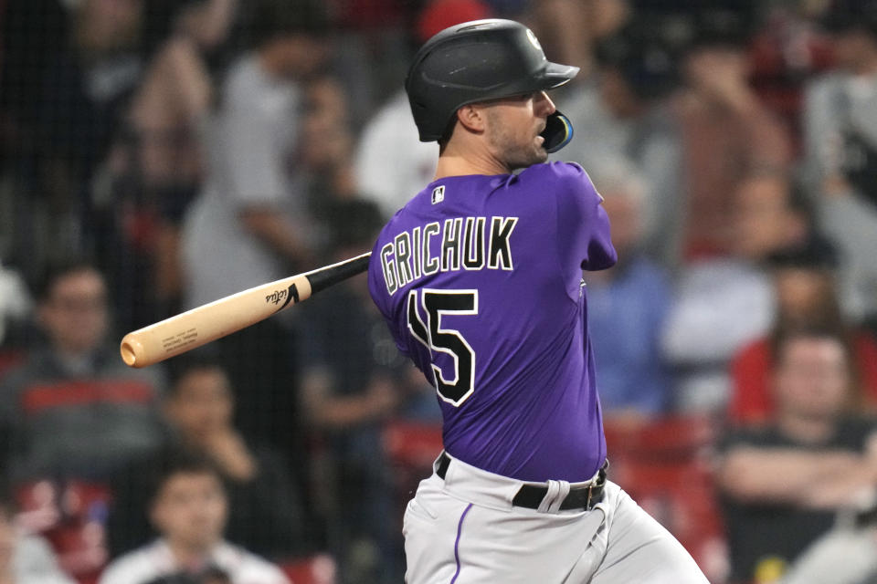 Colorado Rockies' Randal Grichuk watches the flight of his two RBI double in the tenth inning during a baseball game against the Boston Red Soxat Fenway Park, Tuesday, June 13, 2023, in Boston. (AP Photo/Charles Krupa)
