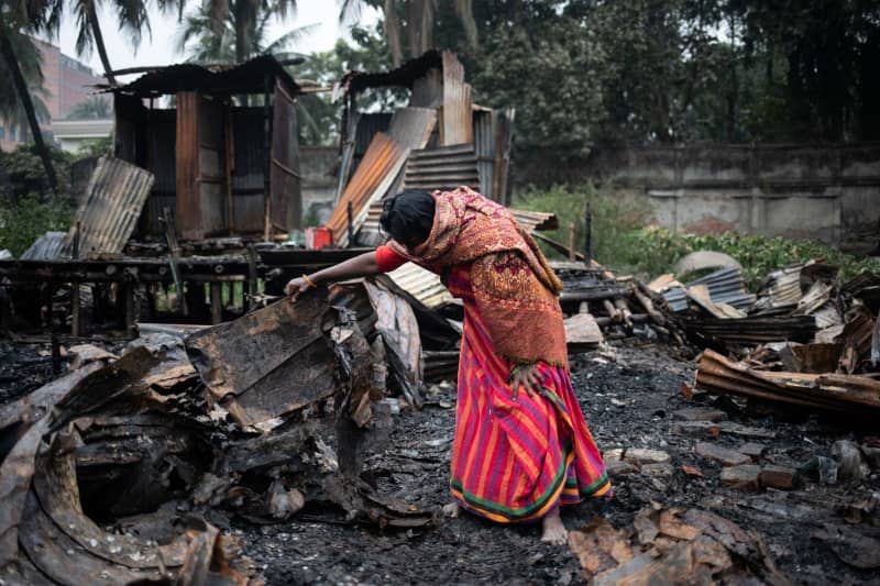 A woman looks at the burnt things of her home at Kawranbazar area. A woman and a child were killed and four others were injured in a fire at slum. Md. Rakibul Hasan/ZUMA Press Wire/dpa