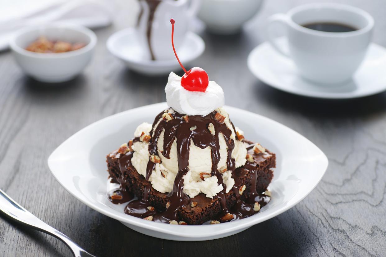 brownie sundae with cherry on top and side cup of coffee