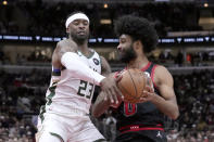 Chicago Bulls' Coby White, right, drives to the basket under pressure from Milwaukee Bucks' Wesley Matthews during the first half of an NBA basketball game Thursday, Feb. 16, 2023, in Chicago. (AP Photo/Charles Rex Arbogast)
