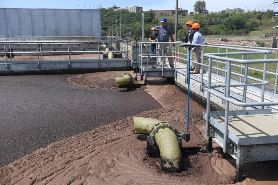 A tour group comprised of Argus Leader and Smithfield Foods staff look at wastewater lagoons during a tour of the meatpacker's new wastewater treatment facility at Smithfield Foods in Sioux Falls, South Dakota on Wednesday, Aug. 16, 2023. Sewage is cycled between the five lagoons, each holding up to 1 million gallons of wastewater, which converts the unwanted nitrate compounds present in the wastewater into nitrogen gas, a cleaner emission which is not deposited into the Big Sioux River.