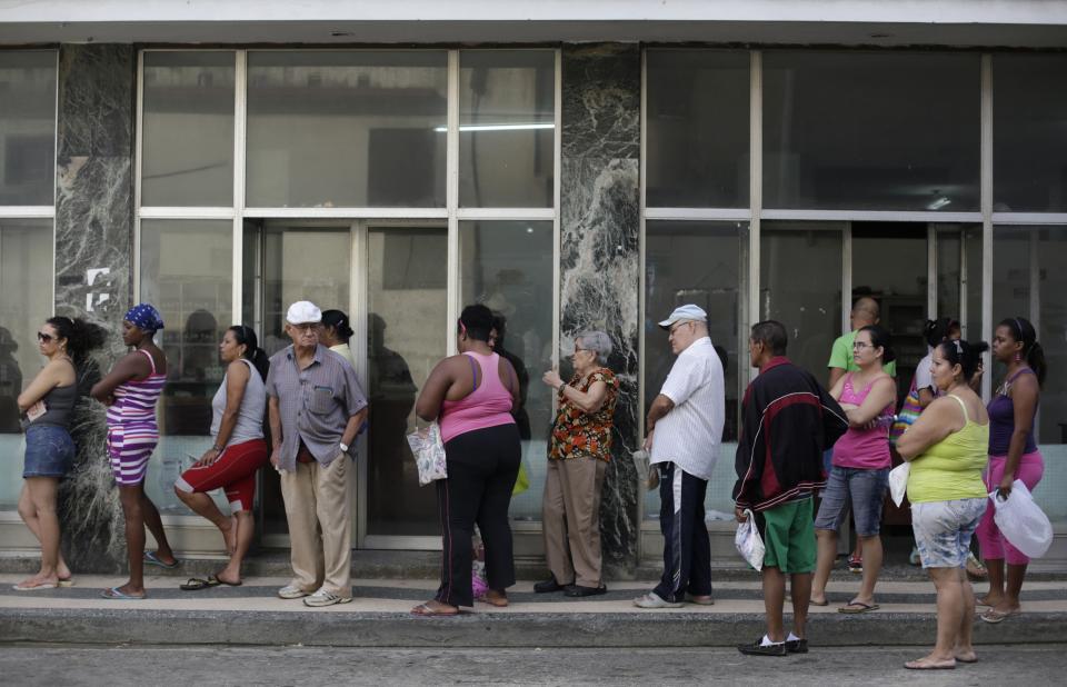 People line up outside a state pharmacy to buy medicine in Havana December 27, 2014. Cuba's most prominent dissidents say they have been kept in the dark by U.S. officials over a list of 53 political prisoners who will be released from jail as part of a deal to end decades of hostility between the United States and Cuba. Picture taken December 27, 2014. REUTERS/Enrique De La Osa (CUBA - Tags: POLITICS SOCIETY)