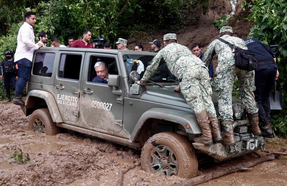 Mexican President Andres Manuel Lopez Obrador’s vehicle is stuck in mud during a visit to the Kilometro 42 community, near Acapulco, Guerrero State, Mexico, after the passage of Hurricane Otis, on October 25, 2023 (AFP via Getty Images)