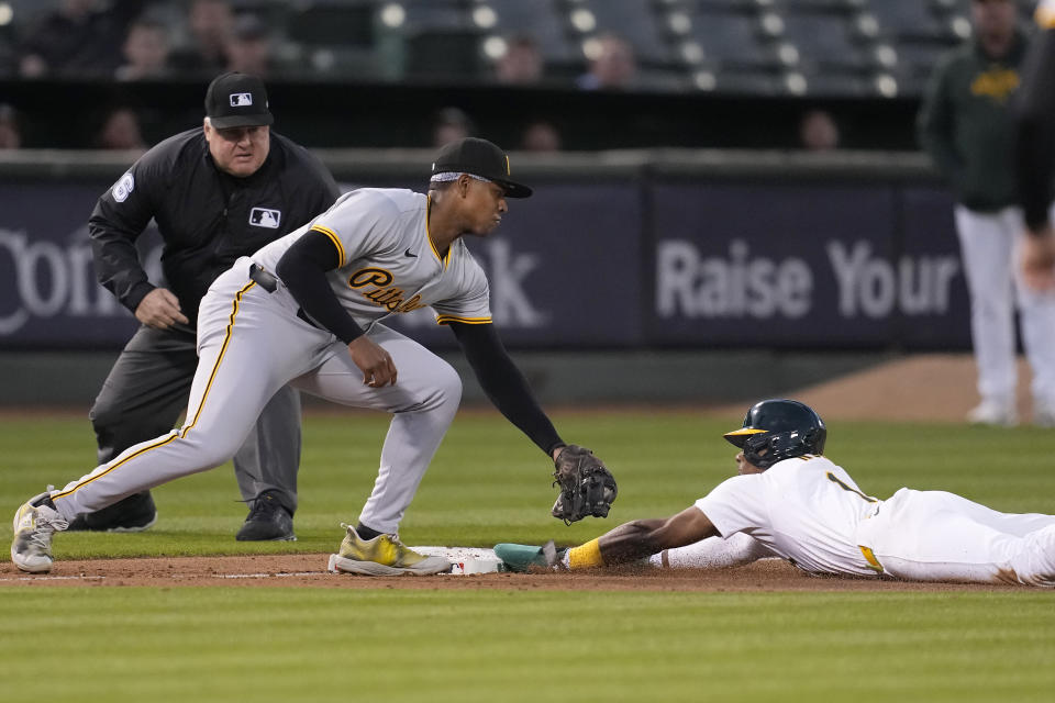 Oakland Athletics' Esteury Ruiz, right, steals third base next to Pittsburgh Pirates third baseman Ke'Bryan Hayes during the fifth inning of a baseball game in Oakland, Calif., Monday, April 29, 2024. (AP Photo/Jeff Chiu)