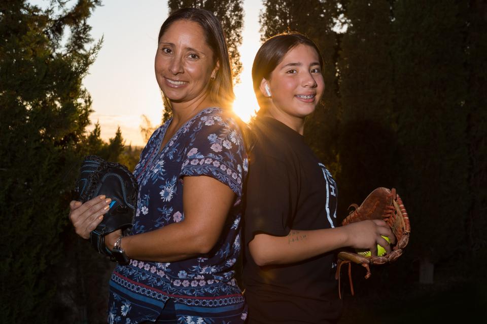 Janice Aguilar-Jaramillo, a student counselor at Don Haskins PK-8 School, stands next to her daughter Ayana at their El Paso home on Tuesday, Sept. 28, 2022. Aguilar-Jaramillo, a decorated pitcher in the late 1990s, was inducted earlier this month into the New Mexico Highlands University Hall of Fame. Life on the mound, Aguilar-Jaramillo says helped prepare for a life-changing moment when her daughter was diagnosed with acute leukemia in November 2015. Ayana, an eighth grader, has been in remission for six years.