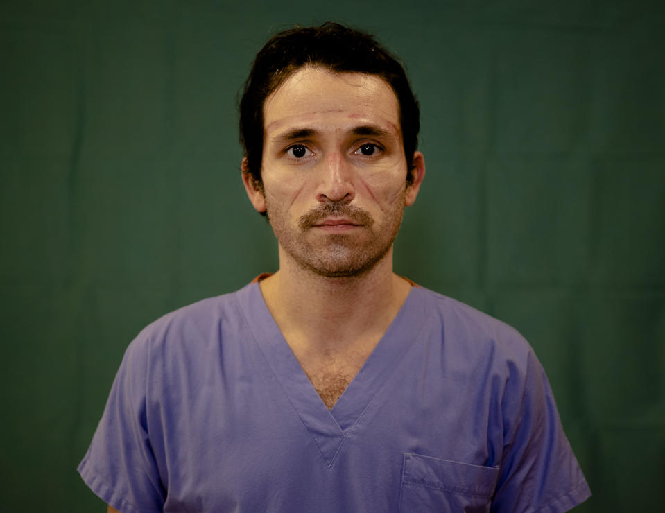 Luca Tarantino, 37, an Emergency nurse at the Humanitas Gavazzeni Hospital in Bergamo, Italy poses for a portrait at the end of his shift Friday, March 27, 2020. The intensive care doctors and nurses on the front lines of the coronavirus pandemic in Italy are almost unrecognizable behind their masks, scrubs, gloves and hairnets. (AP Photo/Antonio Calanni)