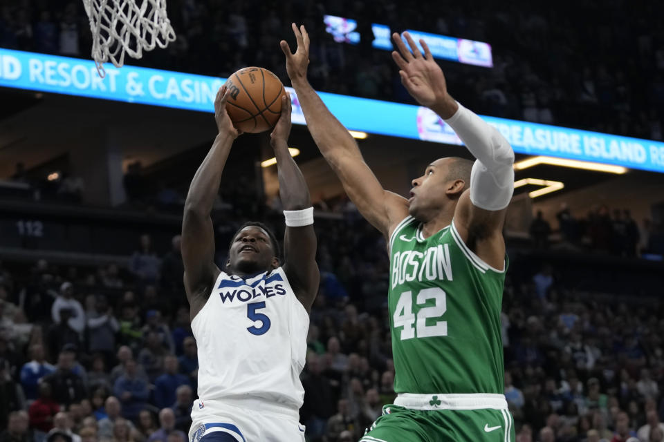 Minnesota Timberwolves guard Anthony Edwards (5) goes up for a shot as Boston Celtics center Al Horford (42) defends during the first half of an NBA basketball game, Monday, Nov. 6, 2023, in Minneapolis. (AP Photo/Abbie Parr)