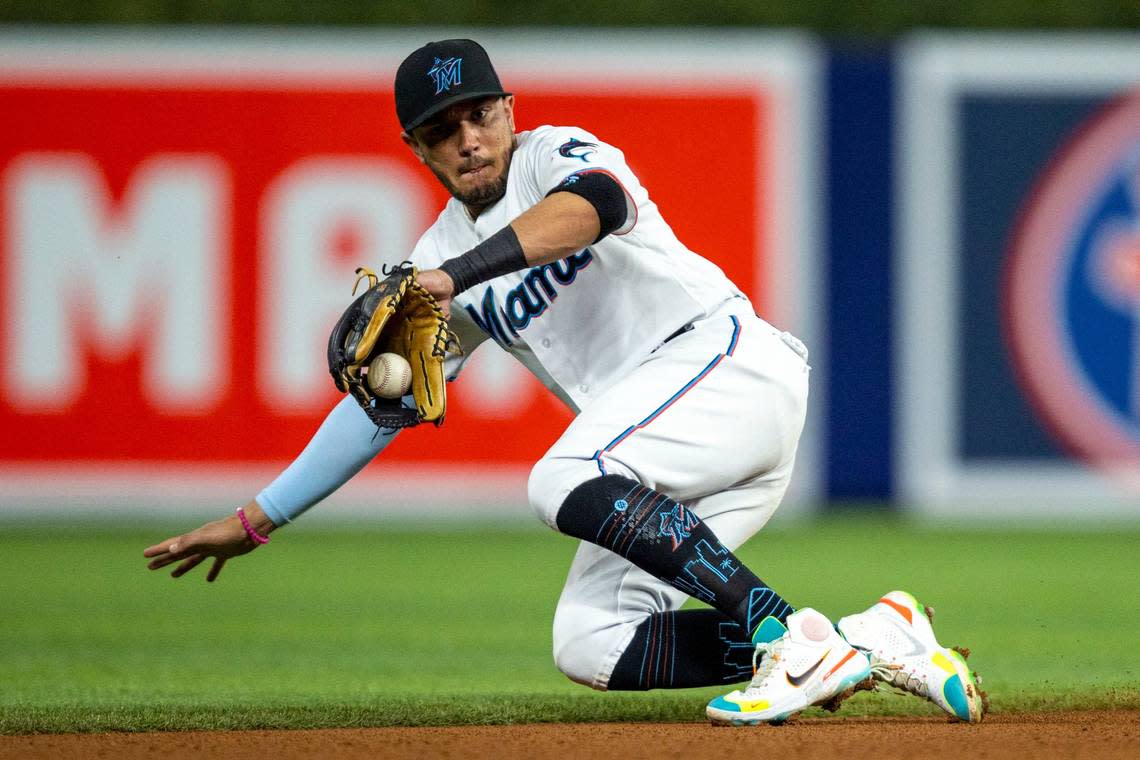 Miami Marlins shortstop Miguel Rojas (11) attempts to grab the ground ball before dropping it during the fourth inning of an MLB game against the Washington Nationals at loanDepot park in the Little Havana neighborhood of Miami, Florida, on Wednesday, June 8, 2022.