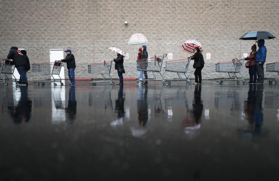 Shoppers wait in line in the rain to enter a Costco Wholesale store on March 14 in Glendale, California.