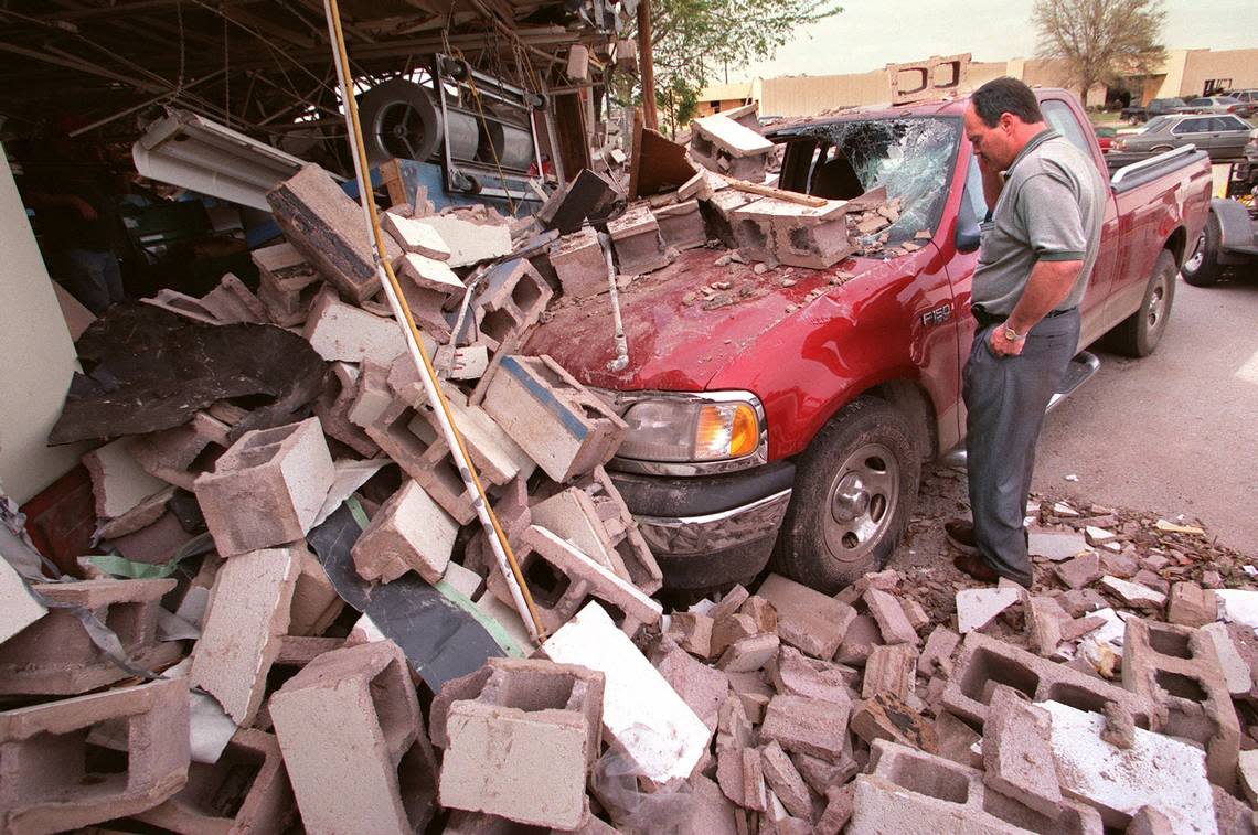 Damon Geer retrieves his stuff from his ’99 Ford F150 truck that was parked behind Metric Motors on Stayton Street just east on Montgomery Ward off West Seventh Street. The wall of Metric Motors collapsed onto his truck while he was ins the Scoreboard Bar under a pool table when a tornado hit on March 28, 2000.