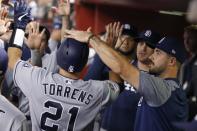 San Diego Padres' Luis Torrens (21) celebrates his run scored against the Arizona Diamondbacks with teammates, including Joey Lucchesi, right, during the seventh inning of a baseball game Friday, Sept. 27, 2019, in Phoenix. (AP Photo/Ross D. Franklin)