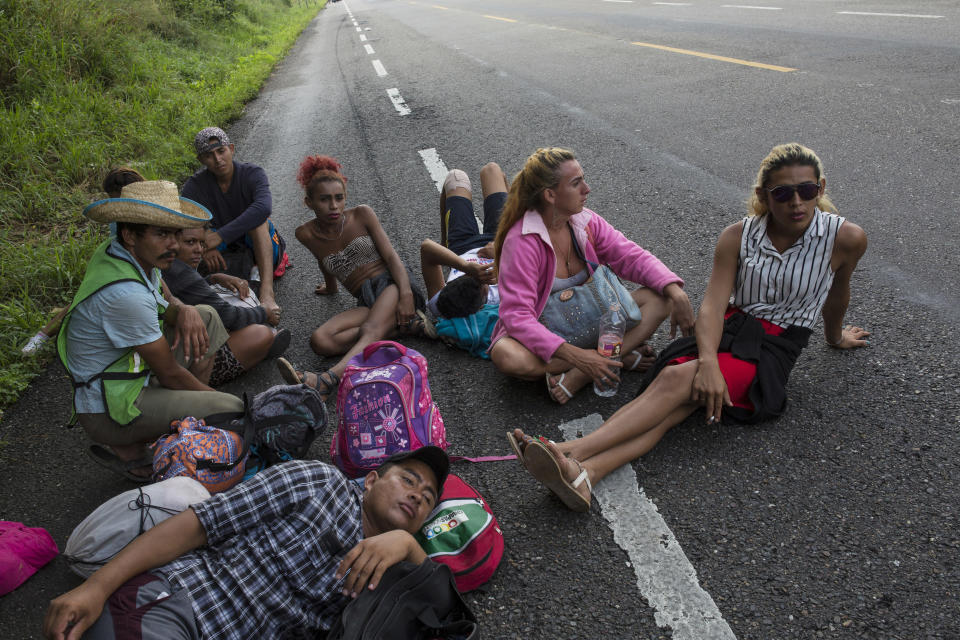 In this Nov. 2, 2018 photo, members of the LGBTQ community who are traveling with the Central American migrants caravan hoping to reach the U.S. border, wait on the side of the road for a ride to Donaji, Mexico. Fearful of being attacked violently or sexually assaulted, they've stuck by each other's side 24 hours a day, walking and sleeping in a group. (AP Photo/Rodrigo Abd)