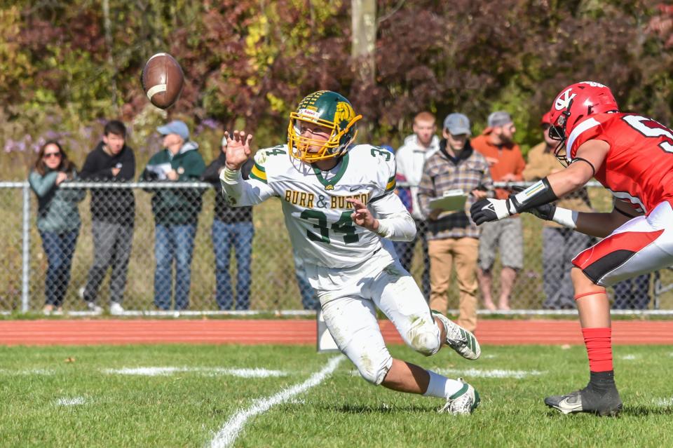 Burr and Burton's Jack McCoy pitches the ball to his running back during the Bulldogs' game vs. the CVU Redhawks last fall.