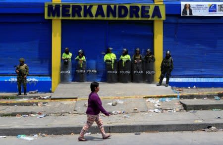 Colombian police and soldiers guard a supermarket supposedly linked to FARC in Bogota, Colombia February 21, 2018. REUTERS/Jaime Saldarriaga