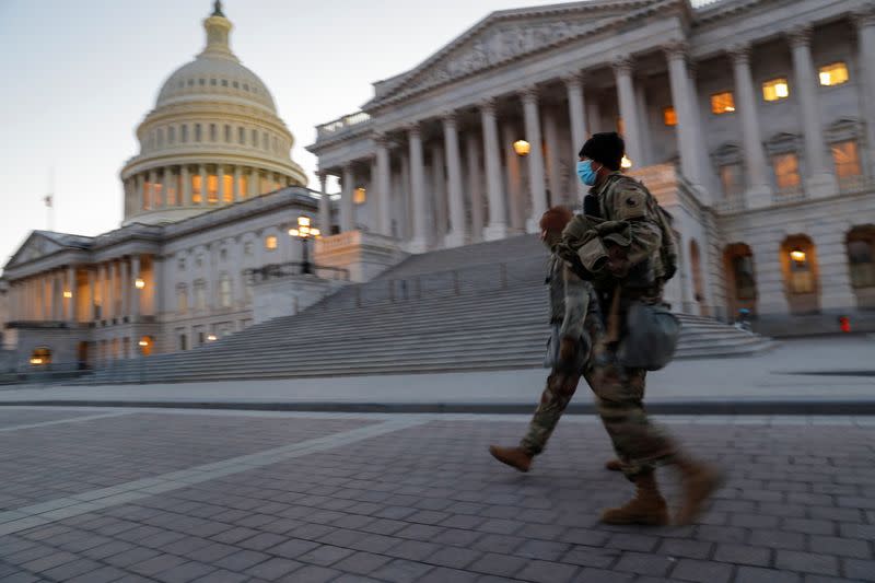 U.S. National Guard members walk near the U.S. Capitol Building on Capitol Hill in Washington