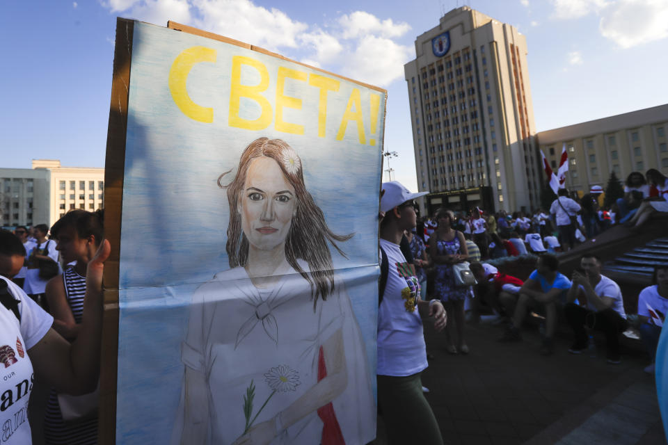 People carry a portrait of Sviatlana Tsikhanouskaya, former candidate for the presidential elections during opposition rally in front of the government building in Minsk, Belarus, Monday, Aug. 17, 2020. Lukashenko's main challenger, Sviatlana Tsikhanouskaya, who fled on Tuesday to neighbouring Lithuania, posted a new video in which she disputed the results of the vote and demanded that the government start a dialogue with demonstrators. (AP Photo/Sergei Grits)