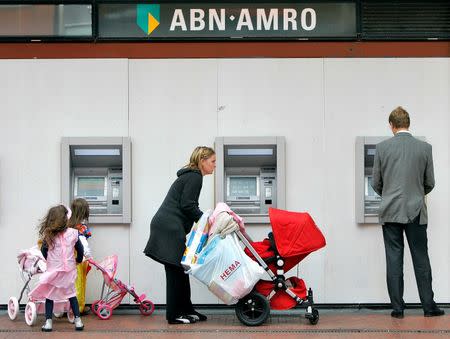 Customers use the ATM machines of the ABN-AMRO Bank in Amstelveen, May 29, 2007. REUTERS/Koen van Weel