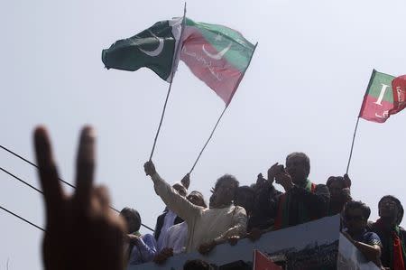 Imran Khan, chairman of Pakistan Tehreek-e-Insaf (PTI) political party, waves a national flag from a truck as he leads the Freedom March in Lahore August 14, 2014. REUTERS/Akhtar Soomro