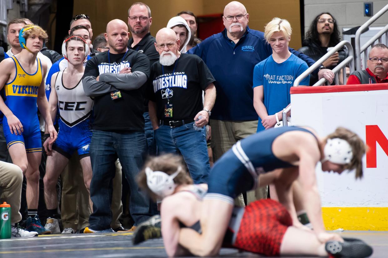 Wrestlers and coaches watch as Northwestern's Sierra Chiesa (bottom) works her way to a 4-2 win over Philipsburg-Osceola's Caleb Hummel in a 107-pound consolation bout at the PIAA Class 2A Wrestling Championships at the Giant Center on March 10, 2023, in Derry Township.