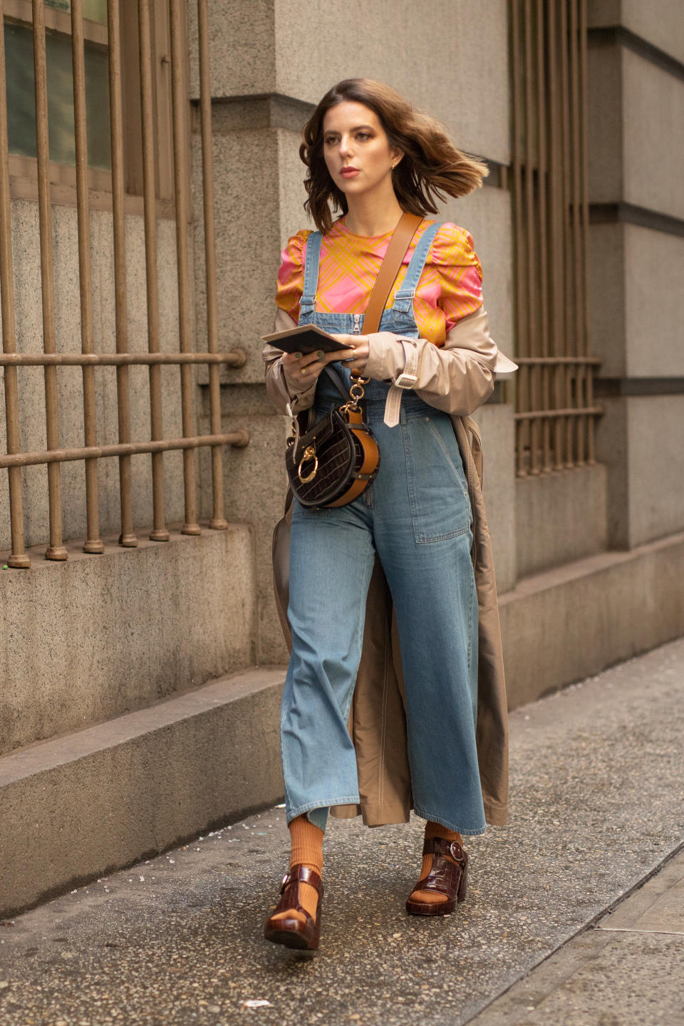 NEW YORK, NEW YORK - FEBRUARY 13: A guest is seen on the street during New York Fashion Week AW19 wearing denim overalls with orange ruffle shirt and brown heels on February 13, 2019 in New York City. (Photo by Matthew Sperzel/Getty Images)