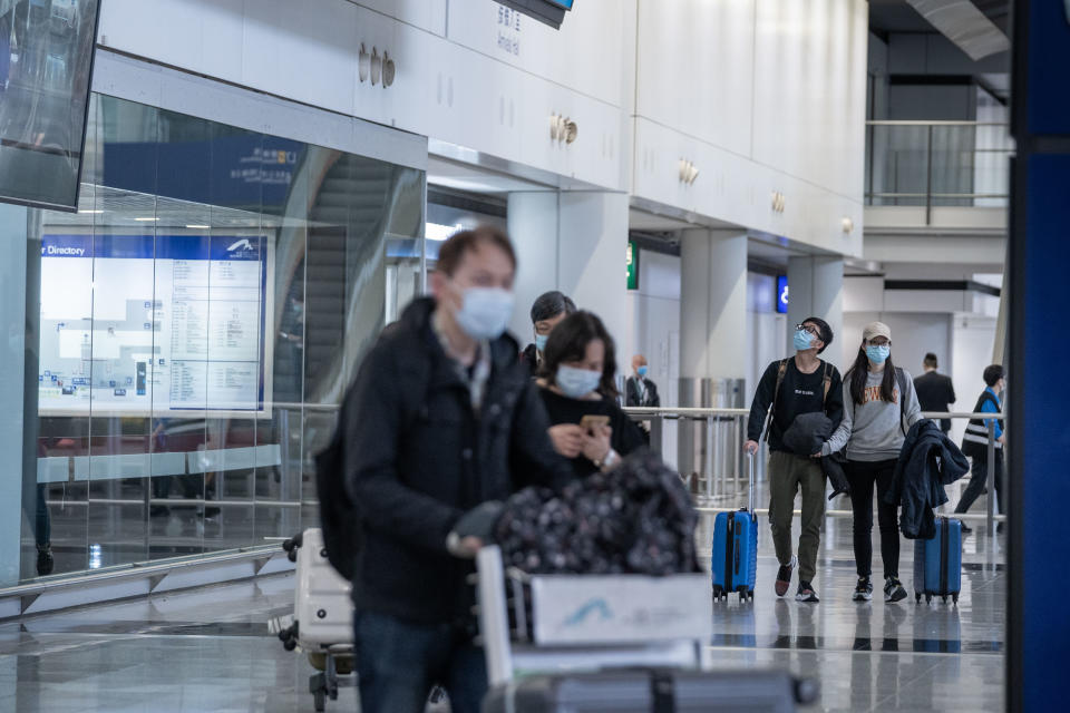  Travelers seen wearing surgical masks as a protective measure from the deadly coronavirus as they exit the arrival hall area at Hong Kong international airport. Hundreds of flights between mainland Chinese cities and Hong Kong cancel as the 14 days mandatory quarantine measure which travelers will have to stay at home or hotel to be quarantined takes into effect. (Photo by Geovien So / SOPA Images/Sipa USA) 