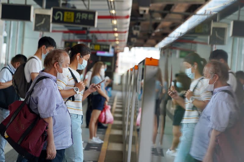 People wait for the train at a subway station in Hong Kong