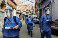 Members of the "Bora Testar" or Let's Test project, walk through the the Paraisopolis neighborhood of Sao Paulo, Brazil, Friday, Sept. 11, 2020. The project plans to test up to 600 people for COVID-19 in the low income neighborhood, and to expand to other vulnerable communities in the country, financed by crowdfunding and donations. (AP Photo/Carla Carniel)