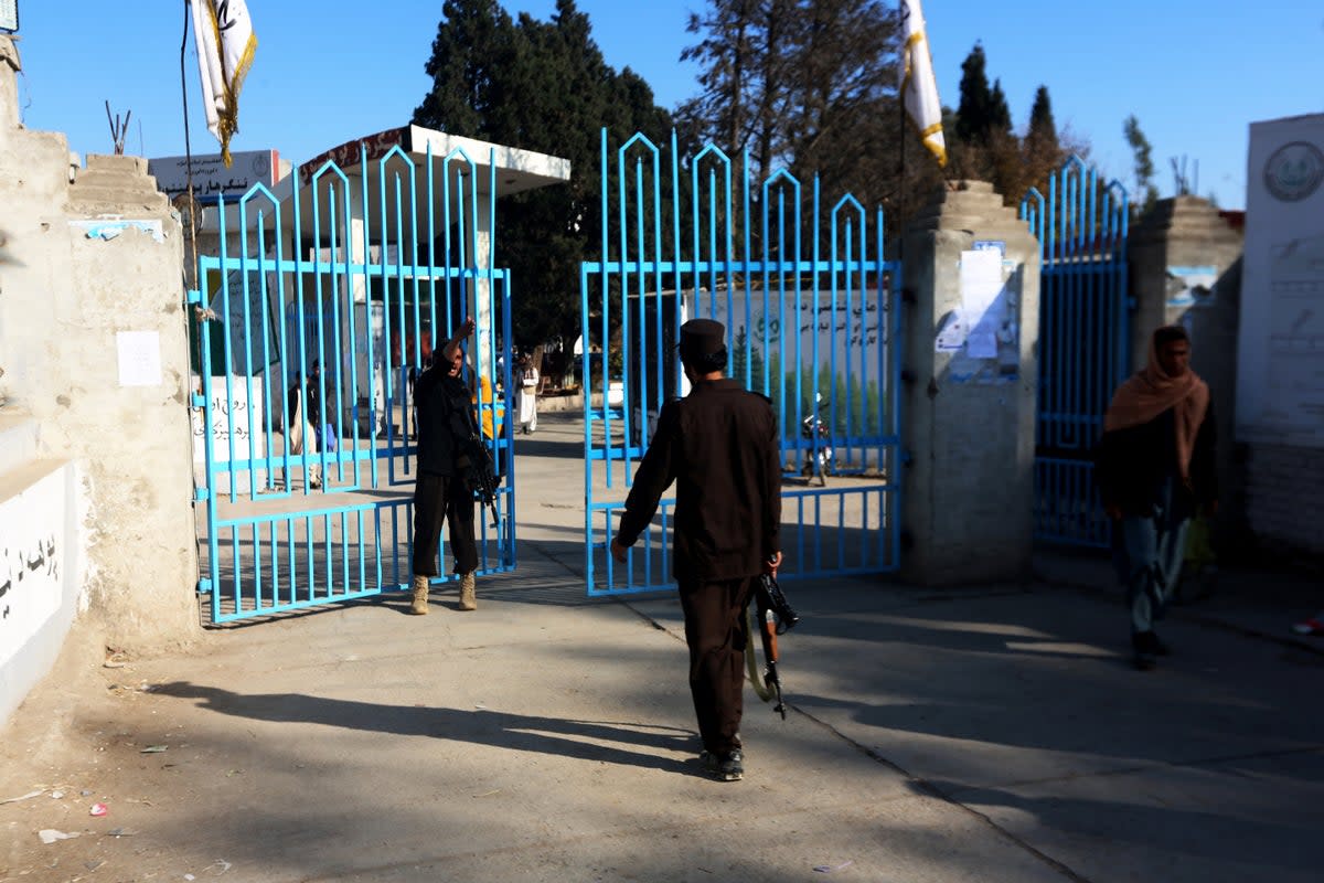 Taliban security personnel stand guard at the entrance gate of a university in Jalalabad on 21 December (AFP via Getty Images)