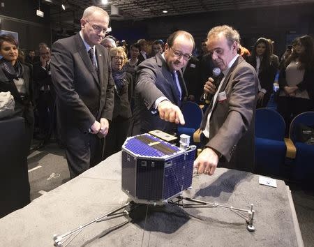 French National Centre for Space Studies (CNES) president Jean-Yves Le Gall (L), French President Francois Hollande (C) and astrophysicist Francis Rocard inspect a scale model of Rosetta lander Philae as they visit the Cite des Sciences at La Villette in Paris as they follow the successful landing of the Philae lander on comet 67P/ Churyumov-Gerasimenko, November 12, 2014. REUTERS/Jacques Brinon/Pool
