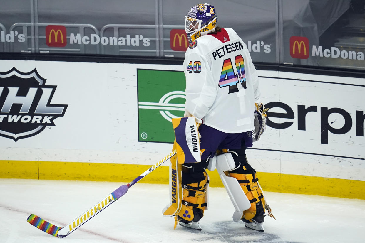 FILE - Los Angeles Kings goaltender Calvin Petersen (40) wears a Pride-themed jersey and holds a stick wrapped in rainbow tape for Pride night while warming up before an NHL hockey game Monday, April 26, 2021, in Los Angeles. At least one National Hockey League team with a Russian player on its roster has decided against wearing special warmup jerseys to commemorate Pride Night because of a Russian law that expands restrictions on activities seen as promoting LGBTQ rights. (AP Photo/Ashley Landis, File)