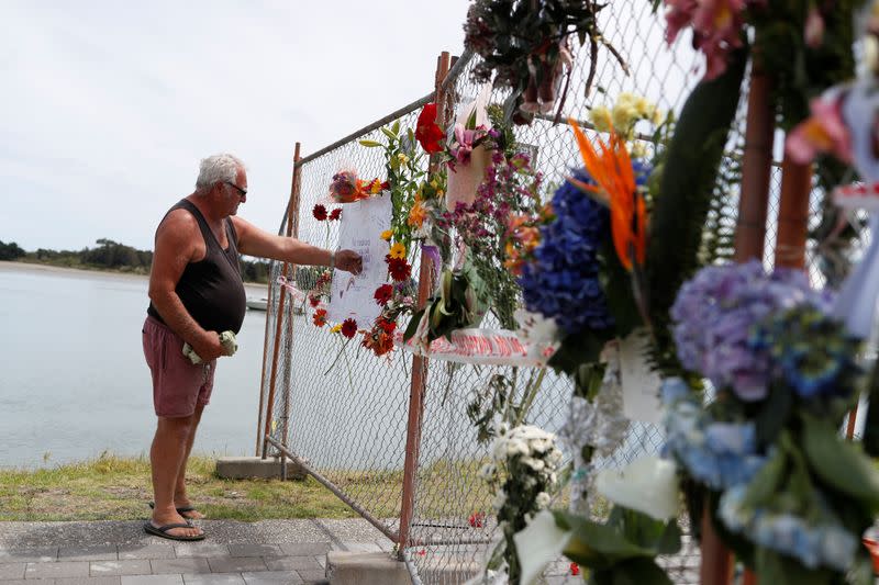 A man looks at a memorial at the harbour in Whakatane, following the White Island volcano eruption in New Zealand