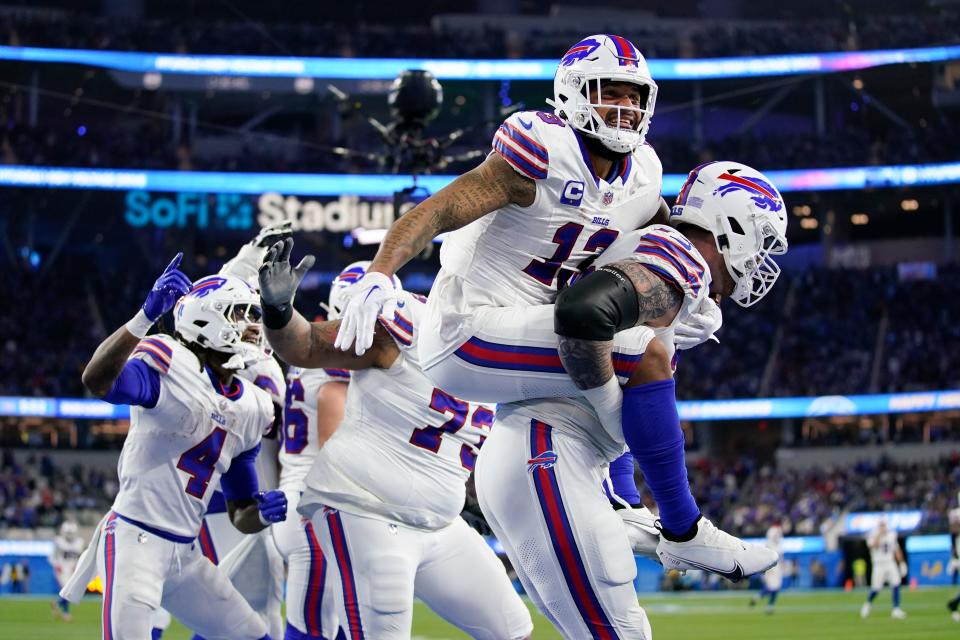 Buffalo Bills wide receiver Gabe Davis (13) is lifted by offensive tackle Spencer Brown (79) after Davis' touchdown reception against the Los Angeles Chargers during the first half of an NFL football game Saturday, Dec. 23, 2023, in Inglewood, Calif. (AP Photo/Ashley Landis)