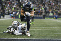Seattle Seahawks running back Travis Homer (25) scores a touchdown against the Las Vegas Raiders during the second half of an NFL football game Sunday, Nov. 27, 2022, in Seattle. (AP Photo/Caean Couto)